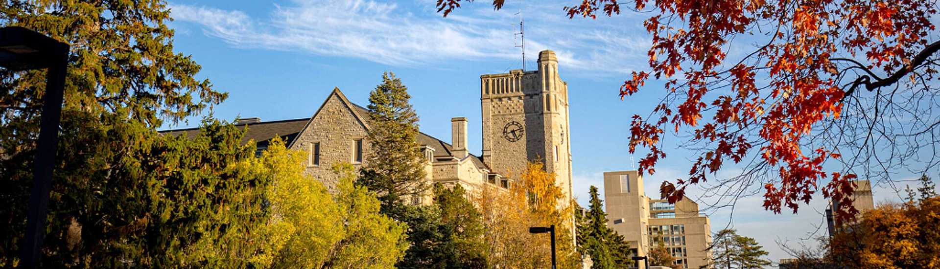 Johnston Hall at the University of Guelph on a bright autumn day with vibrant fall foliage